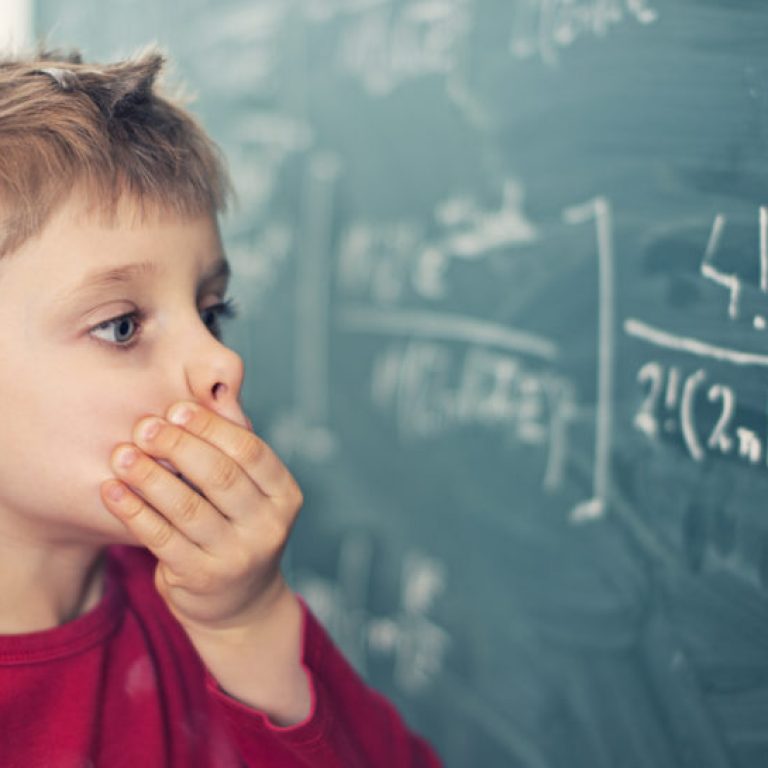 Little boy aged 5 in math class overwhelmed by the math formula.