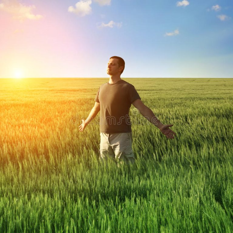 uomo-nel-campo-di-frumento-e-nella-luce-solare-26896881